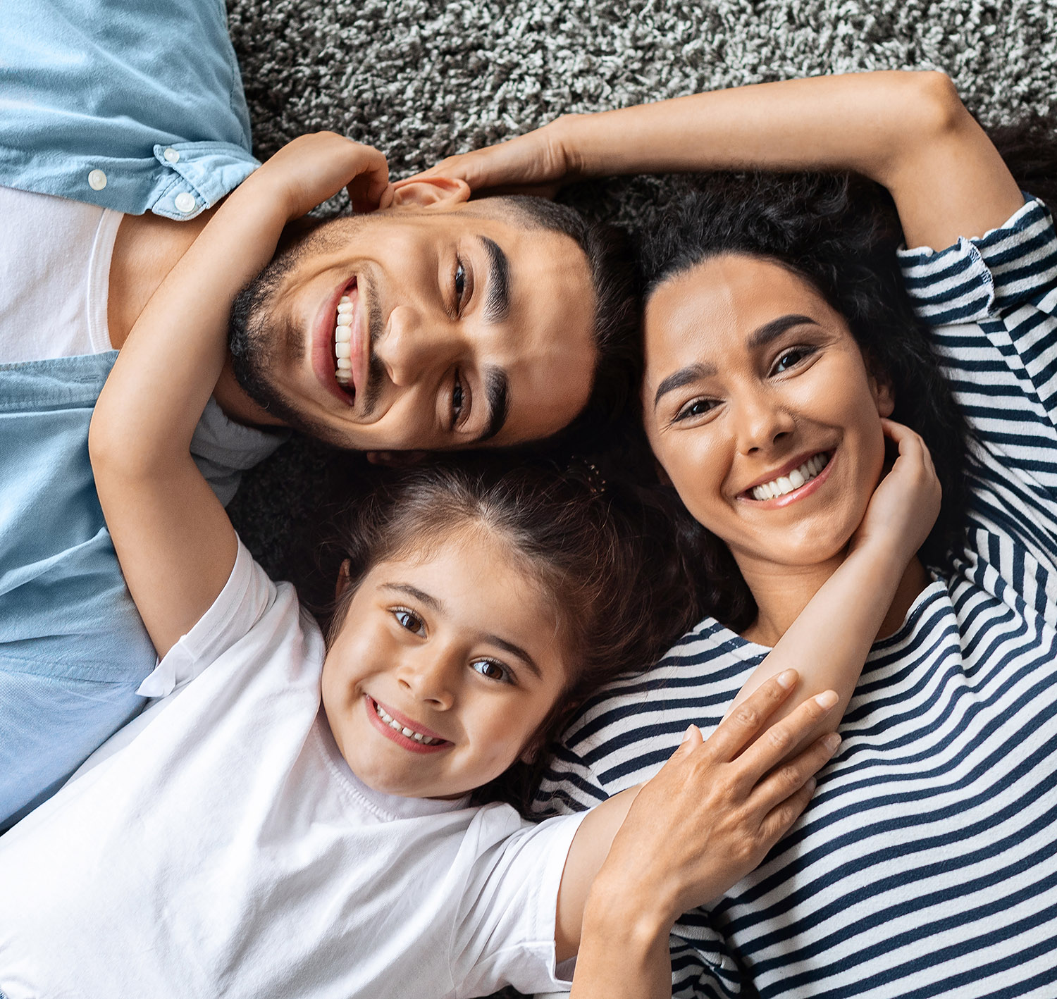 Closeup portrait of happy middle-eastern family cuddling on floor