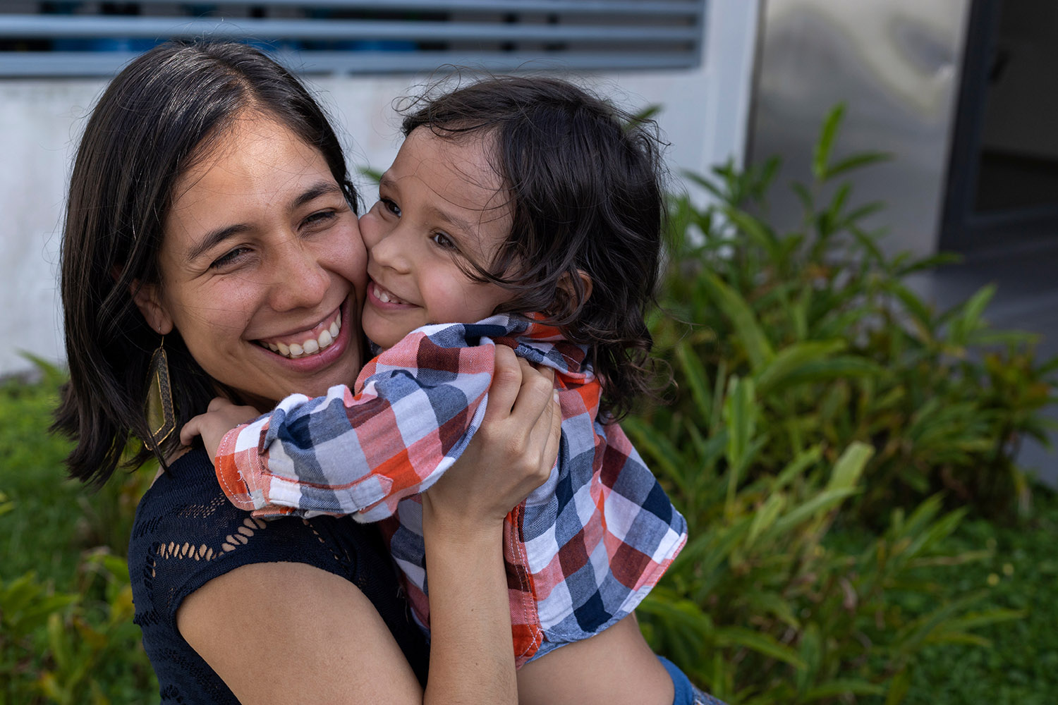 Mom and her Latin American son show their love with hugs and smi